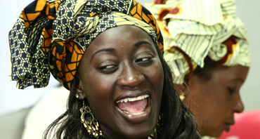 faccia di donna africana molto sorridente con foulard leopardato in testa